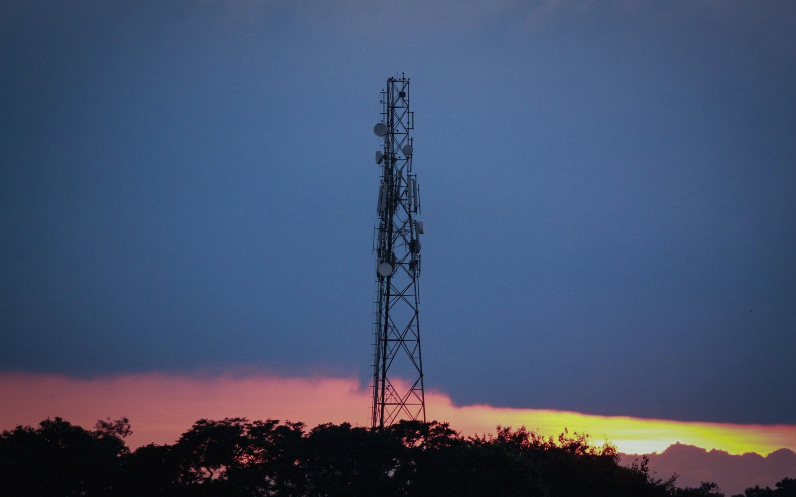 a lattice transmitter mast against the evening sky